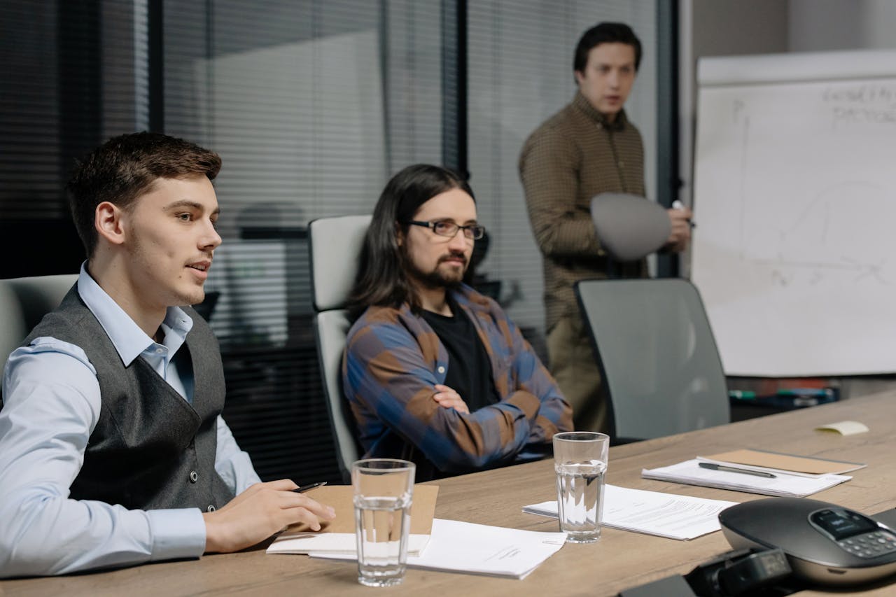 about-01 Colleagues discussing ideas in a modern office meeting.